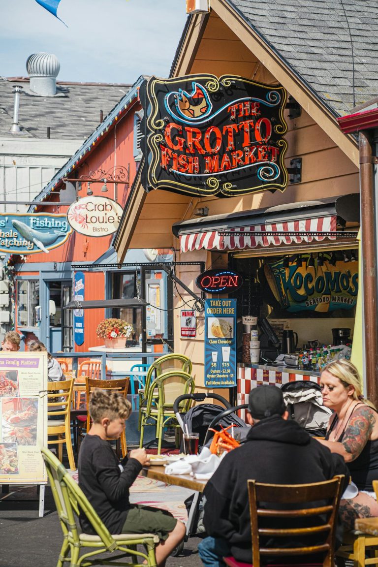 A family enjoys a meal at The Grotto Fish Market in Monterey, CA. Casual outdoor dining atmosphere.