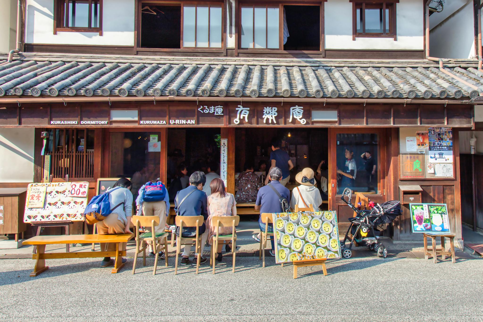 Charming traditional restaurant in Kurashiki, Japan with people seated outside on a sunny day.
