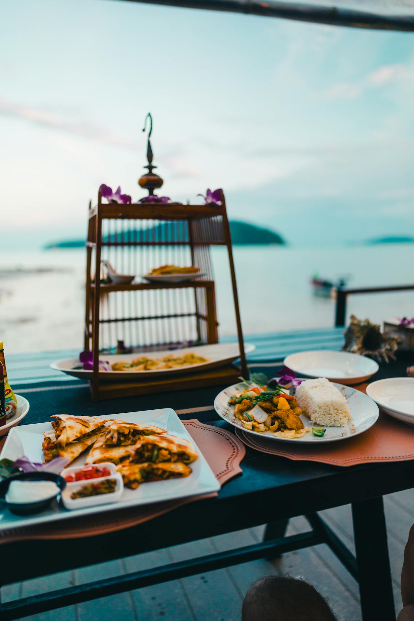 Enjoy a beachside dining experience in Phuket, Thailand with traditional Thai dishes overlooking the sea.