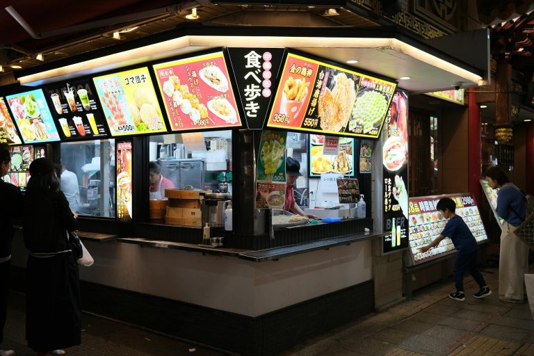 Street food stall in Yokohama, Japan, illuminated and bustling with people in the evening.